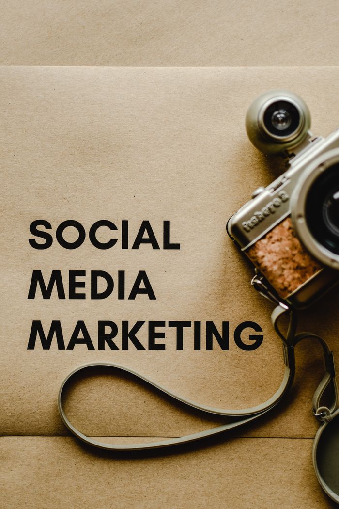 About Close-up of a vintage camera next to a social media marketing concept text on a brown background.